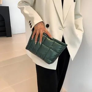 Detailed view of dark green quilted checkered fabric texture on a soft fashion handbag