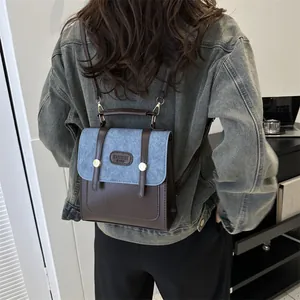 Detail of vintage leather and denim backpack with metallic buckle and fashion brand tag