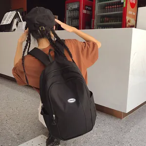 Outdoor view of a black high-capacity backpack featuring a FASHION logo and side pockets