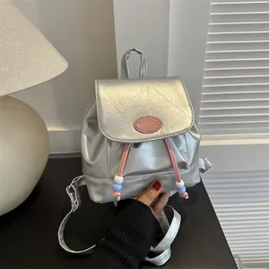 Dettaglio del mini zaino argento con coulisse rosa e accenti di perline colorate