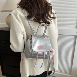 Detail of silver metallic backpack with pink drawstring and plush eye monster charm