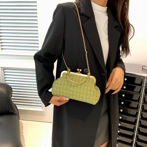 Detail of yellow and green woven clutch bag with gold metal handle and chain strap