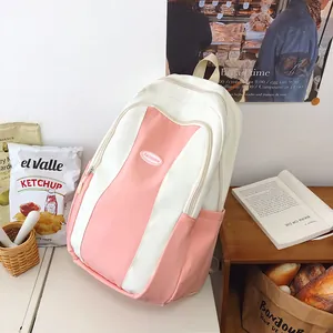 Pink and beige color-block backpack resting on a desk in a cozy lifestyle setting
