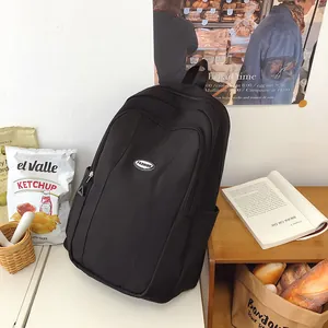 Close-up of black school backpack featuring a fashion logo and multi-pocket design