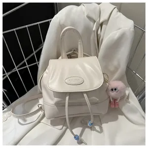 Detail of cream PU leather backpack with Pautor logo and pink plush charm accessory