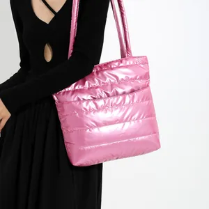Gros plan d'un sac cabas matelassé rose métallisé avec une finition de tissu brillant