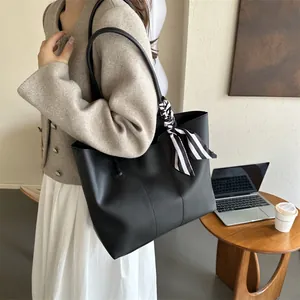 Grande borsa tote nera con nastro a righe mostrata a spalla in un ambiente da ufficio