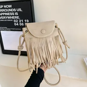 Dettaglio borsa a tracolla beige con nappe, finitura scamosciata e patta frontale