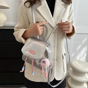 Mini silver metallic backpack with pink details and plush pendant on model