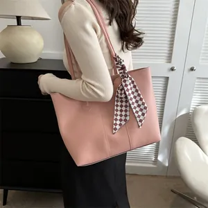 Borsa tote rosa minimalista con dettaglio foulard di seta rosso sulla spalla della modella