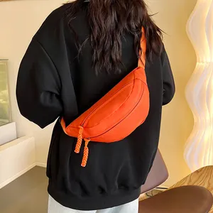 Vue détaillée du dos d'un sac de poitrine en nylon orange vif avec bandoulière réglable