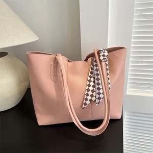 Dettaglio della borsa shopper rosa chiaro con foulard a scacchi marroni sul manico
