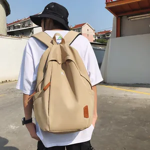 Detail of beige nylon backpack with white letter A print and brown leather tag