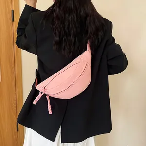 Sac de poitrine minimaliste rose en nylon porté par un mannequin sur un blazer noir