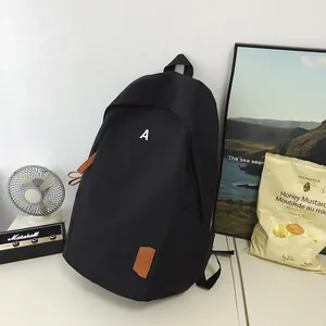 Detail of black nylon backpack side pocket with premium brown zipper pulls in casual setting