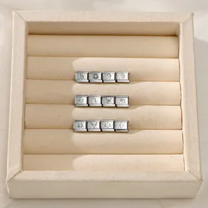 Detailed view of 12 stainless steel Italian charms with engraved zodiac constellation symbols