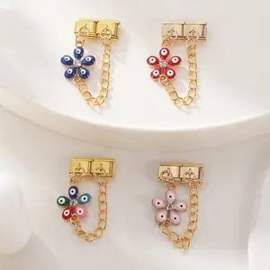 Detail of four Italian charm links with evil eye flower pendants and safety chains