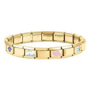 Vue macro du bracelet modulaire en acier doré avec gravures de breloques colorées