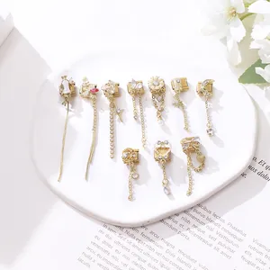 Detail von goldenen italienischen Charms mit Biene, Schmetterling und Quasten auf Teller