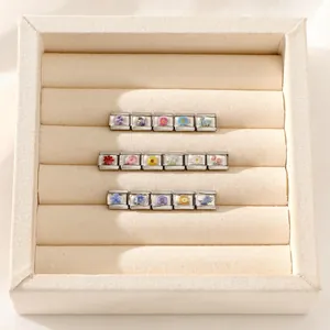 Close-up of 16 Italian charm links with colorful pressed flowers in stainless steel