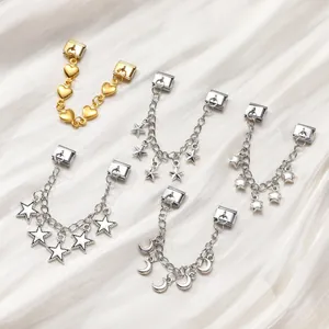 Detailed close-up of modular gold and silver jewelry charms on white satin fabric