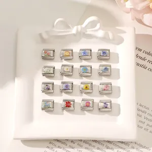 Close-up of 16 Italian charm links with assorted floral patterns on a white ceramic plate