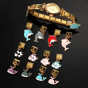 Dettaglio dell'orologio in acciaio dorato con ciondoli animali in smalto colorato