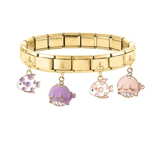Dettaglio dell'incisione STAINLESS STEEL su un bracciale modulare con charm a pesce oro