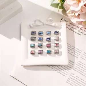 Collection of 16 Italian charms with ocean motifs like starfish and sailboats on a white tray