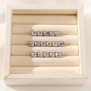 Macro view of Italian modular charms with colorful Y2K patterns in a jewelry tray