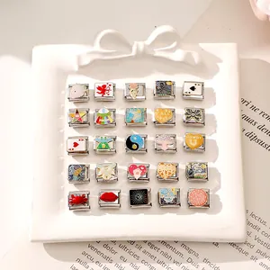 Dettaglio di 25 charm italiani assortiti con motivi in smalto colorato su acciaio