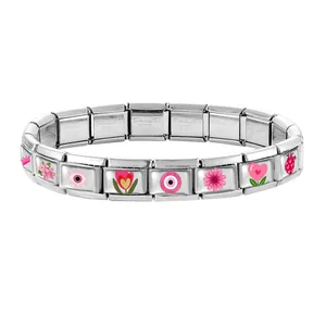 Detail of Italian charm bracelet links featuring pink floral and crown enamel charms