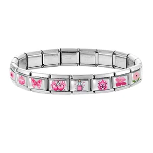 Macro shot of Italian modular bracelet with pink dice, heart and flower stainless steel charms