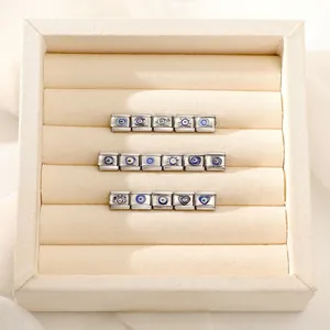Vue macro de breloques italiennes œil bleu et cœur sur une boîte à bijoux en tissu beige