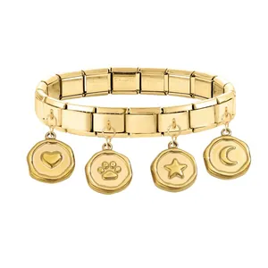 Detailed macro view of gold modular charm bracelet with heart, star, and moon pendants