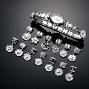 Macro view of modular stainless steel watch charms featuring butterfly and heart charms