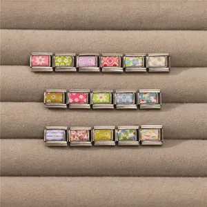 Detailed macro view of stainless steel Italian charm bracelets with floral painted patterns
