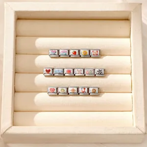 Detail of DIY Italian charm bracelet links with colorful enamel patterns and Dream Big charm
