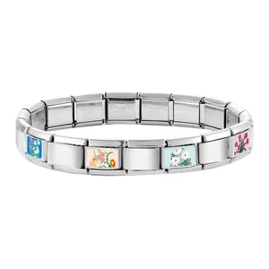 Detailed macro of Italian charm bracelet showing colorful flower links and steel stamp