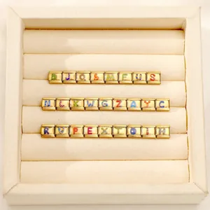 Detail of 26 gold Italian charm links with colorful alphabet letters A to Z in a display box