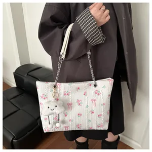 Detail of floral bucket bag with silver chain and white cloud plush charm accessory