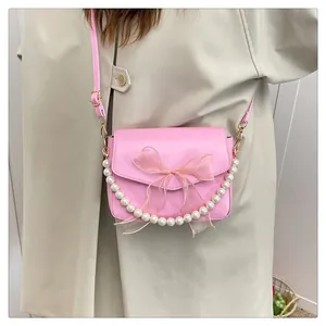 Detailansicht der rosa Ledertasche mit großer Organza-Schleife und Perlen-Handgriff
