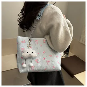 Close-up of floral light blue bucket bag with silver chain and cute cloud charm