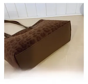 Gros plan des coutures du bas sur un sac cabas imprimé léopard en texture daim brun