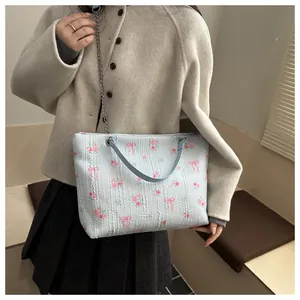 Detailed close-up of light blue floral tote bag with pink roses and silver chain strap