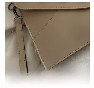 Detailed macro view of the precision stitching on khaki pebbled leather handbag edge