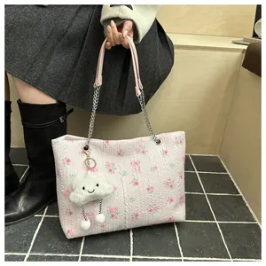 Detail of pink floral jacquard tote bag with silver chain handle and cloud charm