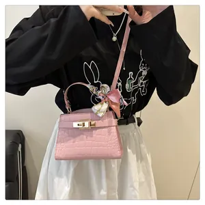 Pink croc-embossed mini handbag with floral silk scarf detail and crossbody strap