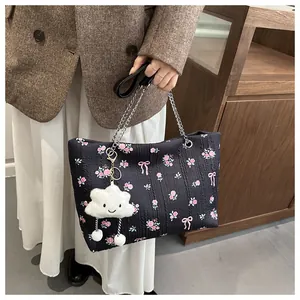 Detail of floral bucket bag with chain strap and cute cloud plush charm accessory
