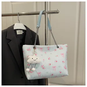Detail of light blue floral bucket bag with rose prints and cloud charm on black blazer